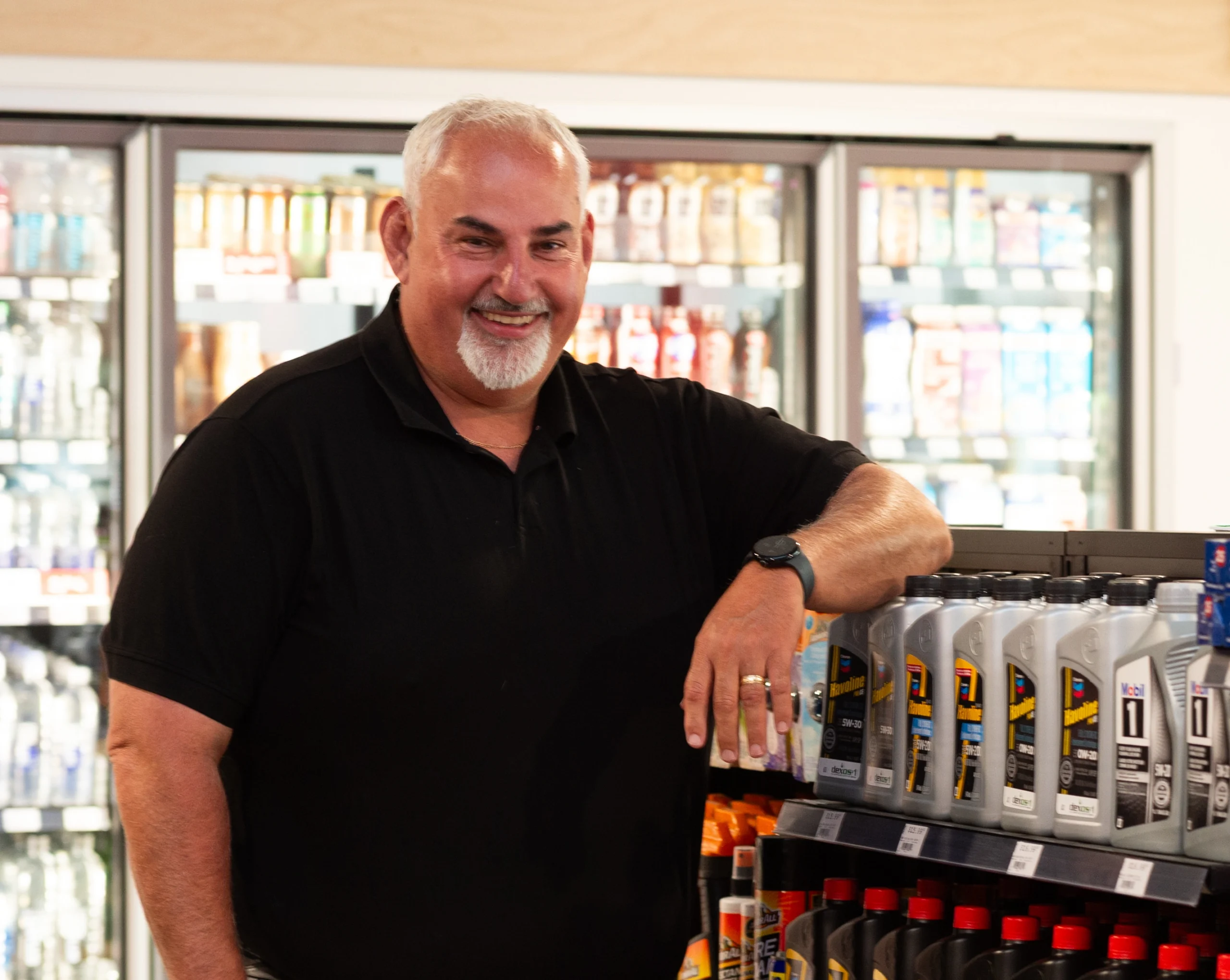 Un employé de dépanneur souriant, les bras croisés