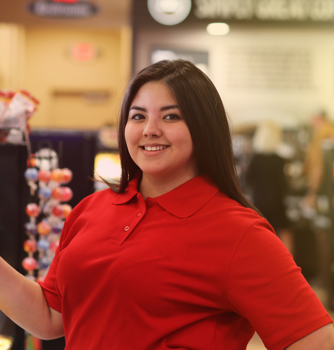 Un employé de dépanneur souriant derrière le comptoir